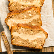 Overhead photo of slices of Cinnamon Apple Bread on a parchment paper lined wood cutting board.