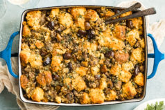 Overhead photo of Chestnut Stuffing in a blue baking dish with serving spoons inserted into the stuffing.