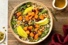 Overhead photo of butternut squash salad with apples, cranberries and rice in a white bowl.