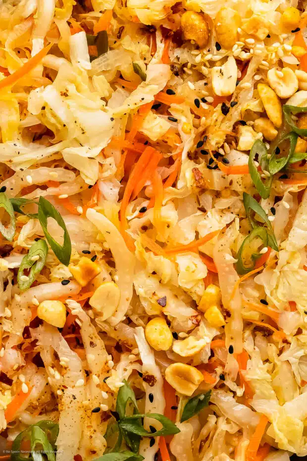 Close up photo of Asian cabbage stir fried with carrots, onions, seasonings, and herbs.