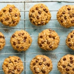Overhead photo of healthy breakfast cookies on a large wire rack with a ramekin of cinnamon next to the rack.