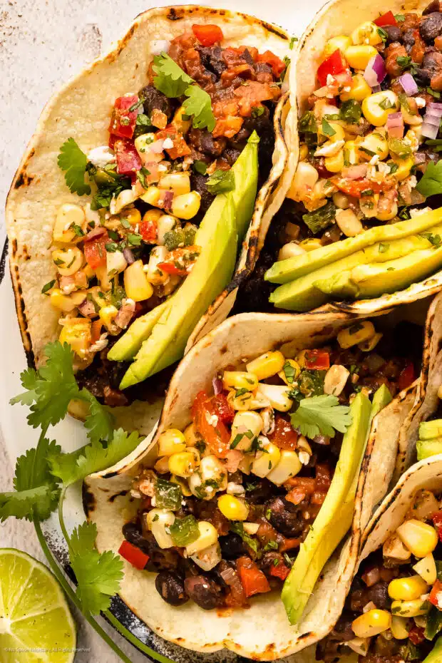 Overhead photo of two tacos with black beans and salsa.