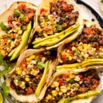 Overhead photo of five beans tacos with corn salsa.