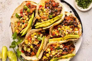 Overhead photo of five beans tacos with corn salsa.