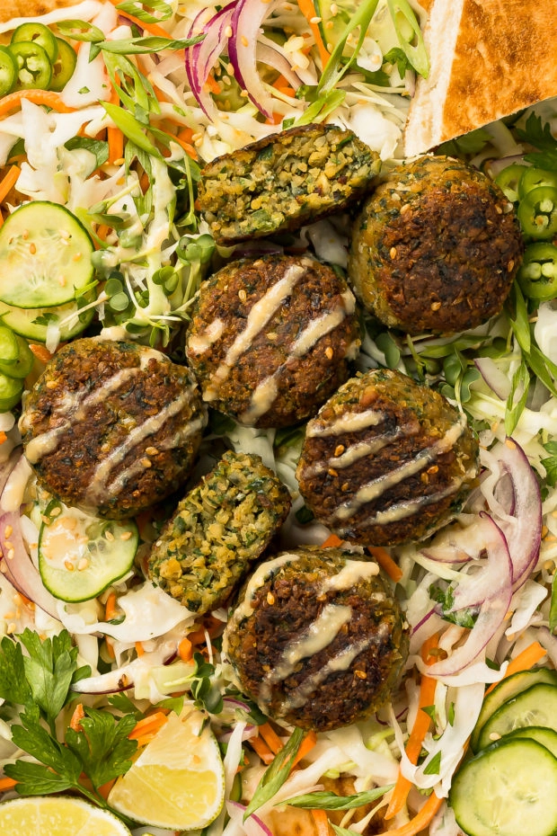 Overhead close-up photo of homemade falafels made with canned chickpeas on a bed of healthy slaw.