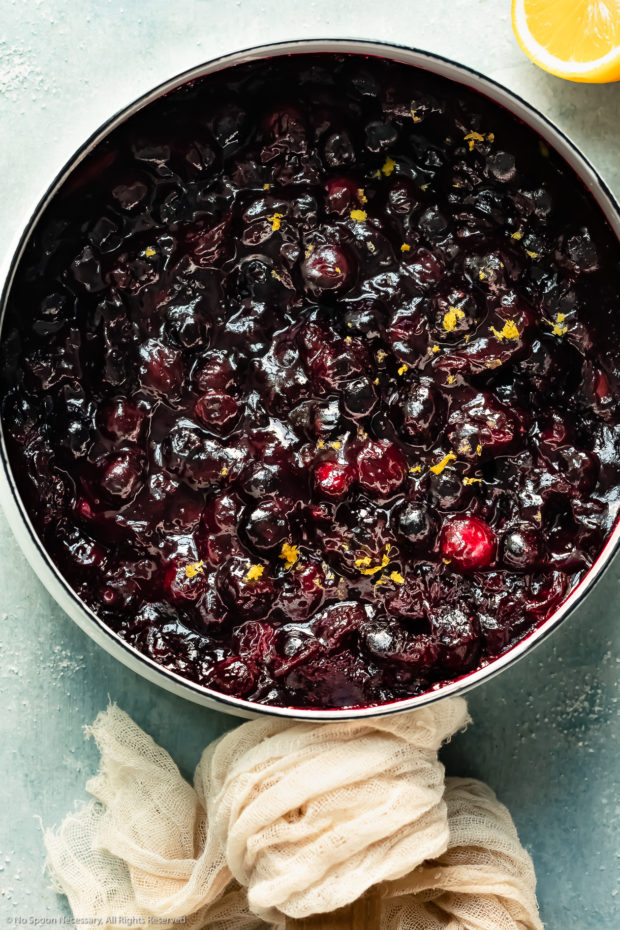 Overhead photo of homemade fresh blueberry pie filling in a white saucepan.