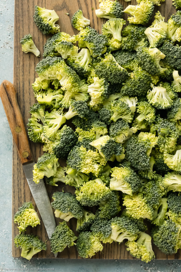 Overhead photo of a head of raw broccoli cut into small florets - photo of how to cut broccoli for salad.