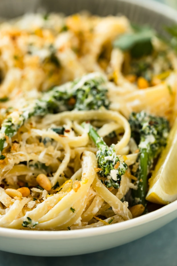 Angled, close-up photo of Creamy Broccoli Pasta in a serving bowl with the focus of the photo on a floret of broccoli.