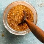 Overhead photo of BBQ Rub in a glass jar with a small wooden spoon inserted into the rub.