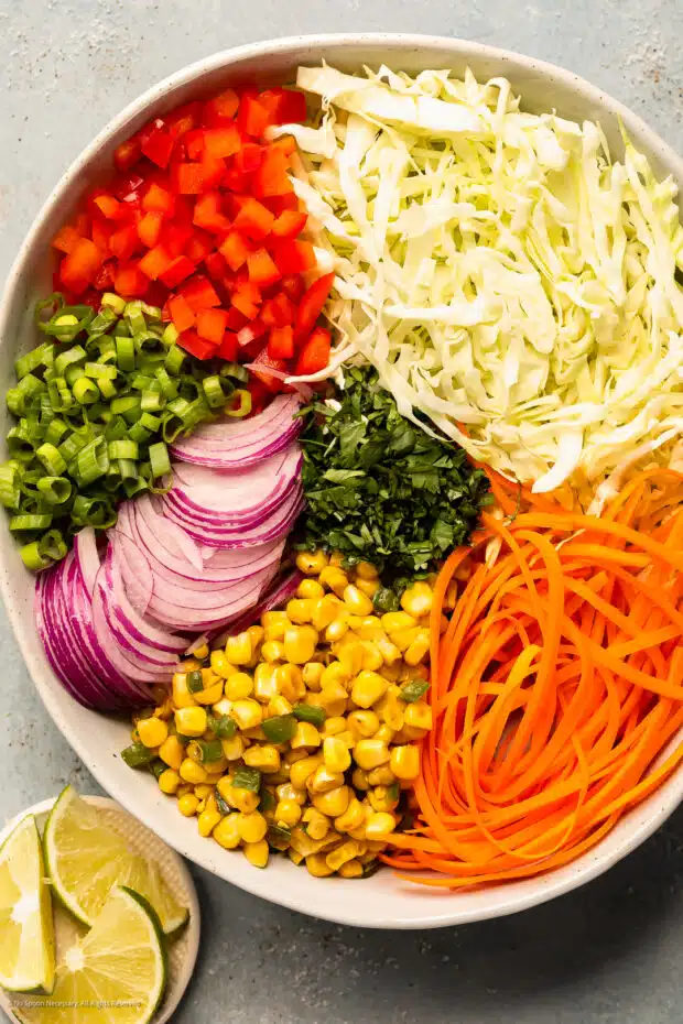 Overhead photo of the ingredients for Mexi slaw neatly arranged in a mixing bowl.