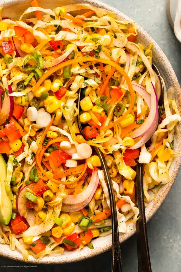 Overhead photo of Mexican coleslaw in a bowl with a serving spoon.