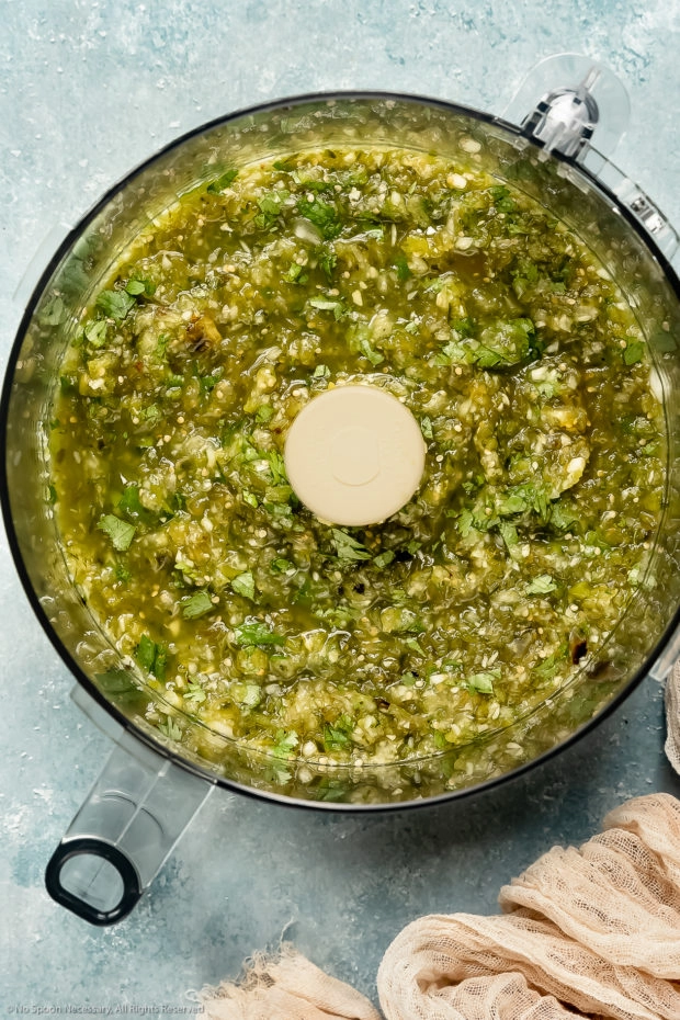 Overhead photo of a food processor bowl filled with Mexican green sauce.