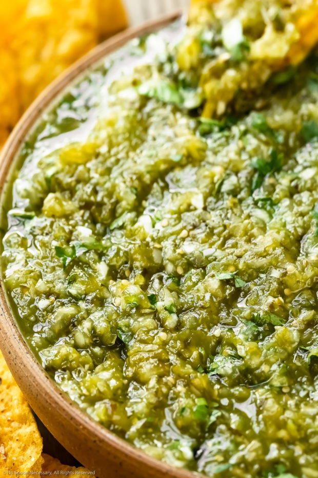 Angled, close-up photo of green Mexican salsa in a snack bowl.