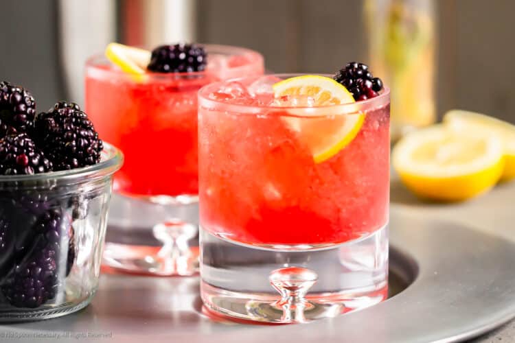 tray of blackberry bramble cocktails with garnish