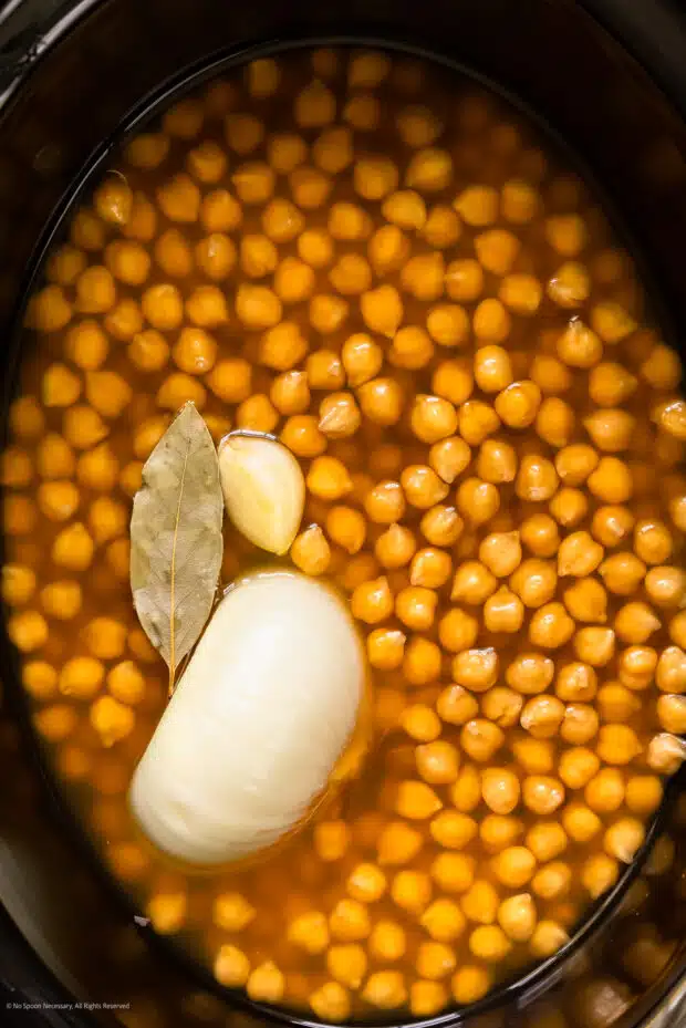 Overhead photo of perfectly plump and tender cooked chickpeas in a slow cooker.