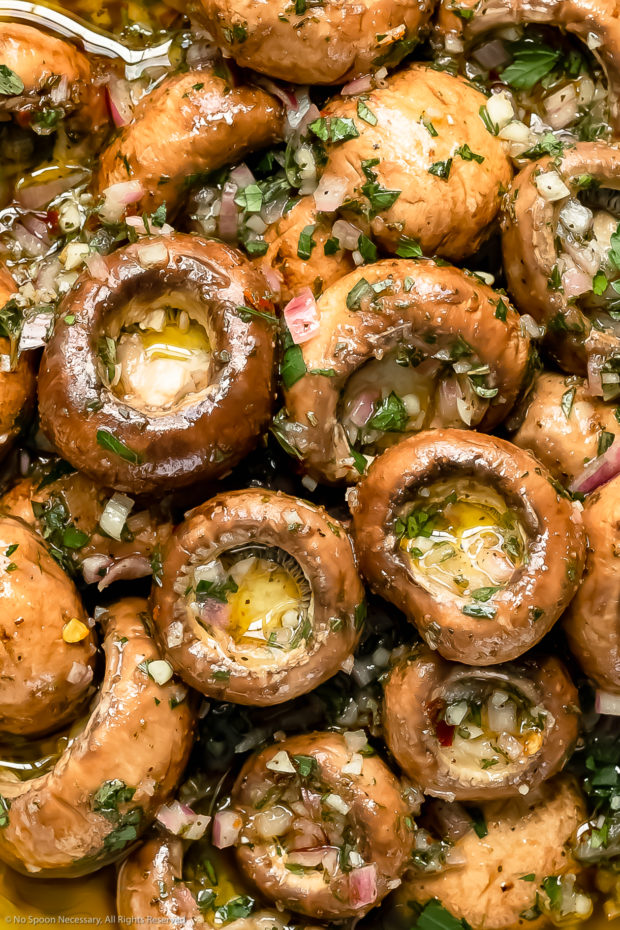 Overhead close-up photo of cremini mushrooms in an Italian marinade.