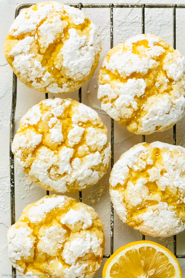 Overhead photo of powdered sugar coated lemon sugar cookies cooling on a wire rack.
