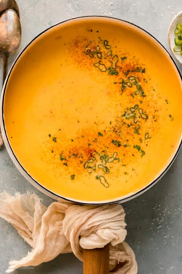 Overhead photo of cheese beer soup in a large white kitchen pot.