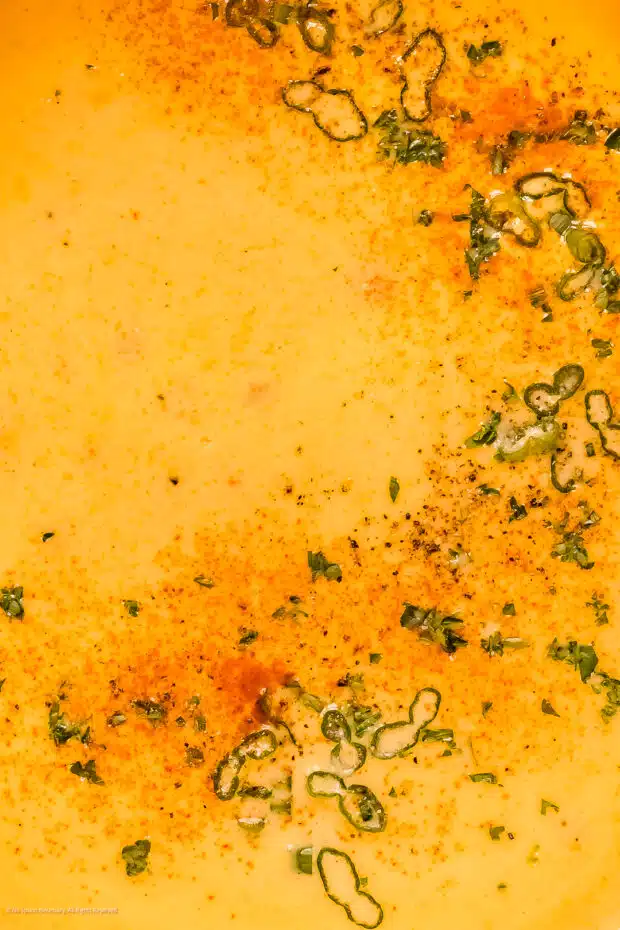 Close-up photo of the fresh herb garnish on a bowl of beer and cheese soup.