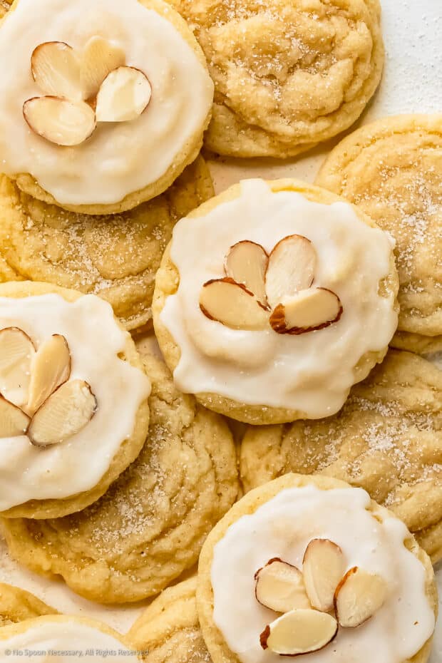 Close-up photo of four sugar cookies with almonds and icing.