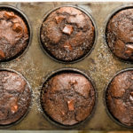 Overhead, close-up photo of double chocolate muffins in a muffin baking pan.
