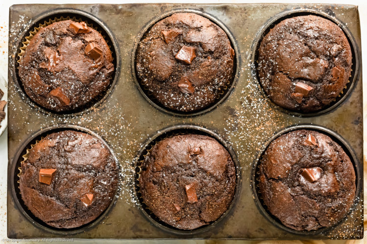 Overhead, close-up photo of double chocolate muffins in a muffin baking pan.
