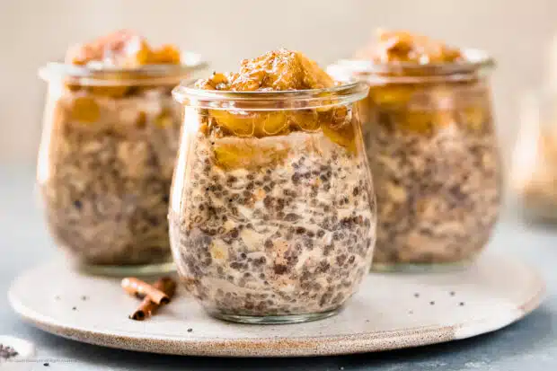Straight on photo of three chia overnight oats with banana topping in glass jars.