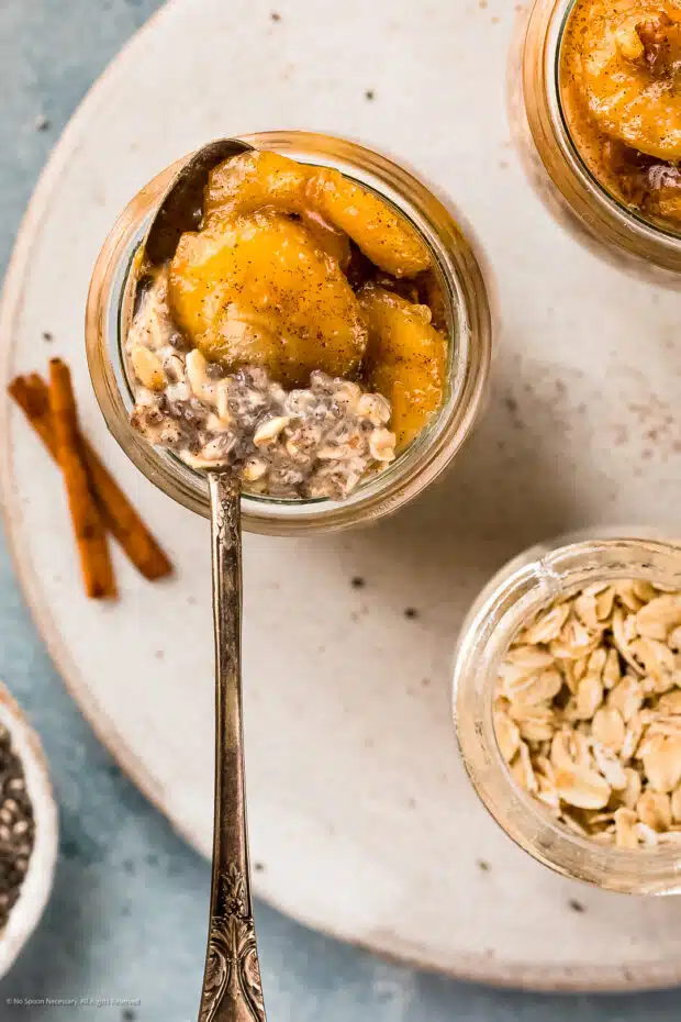 Overhead photo of overnight chia oats in a glass jar with a spoon inserted into the oats.