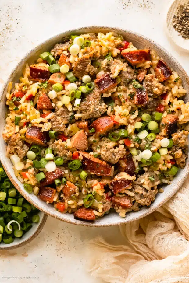 Overhead photo of Dirty Cajun rice with two types of sausages in a white serving bowl.
