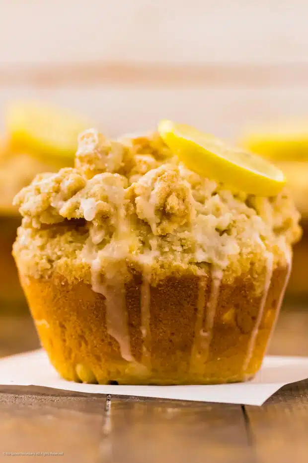 Close-up photo of a freshly baked muffin with crumb topping and glaze. 