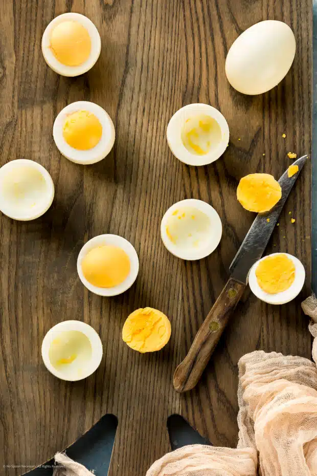 Overhead photo of six perfectly hard boiled eggs cut in half to expose the cooked yolks.