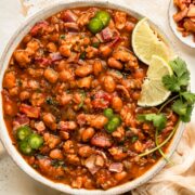 Overhead photo of tender Mexican Beans with chorizo, bacon, and cilantro in a white bowl.