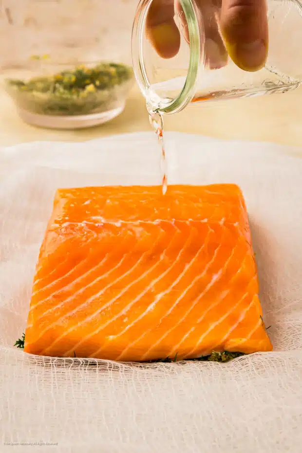 Action photo showing a person making gravlax salmon.