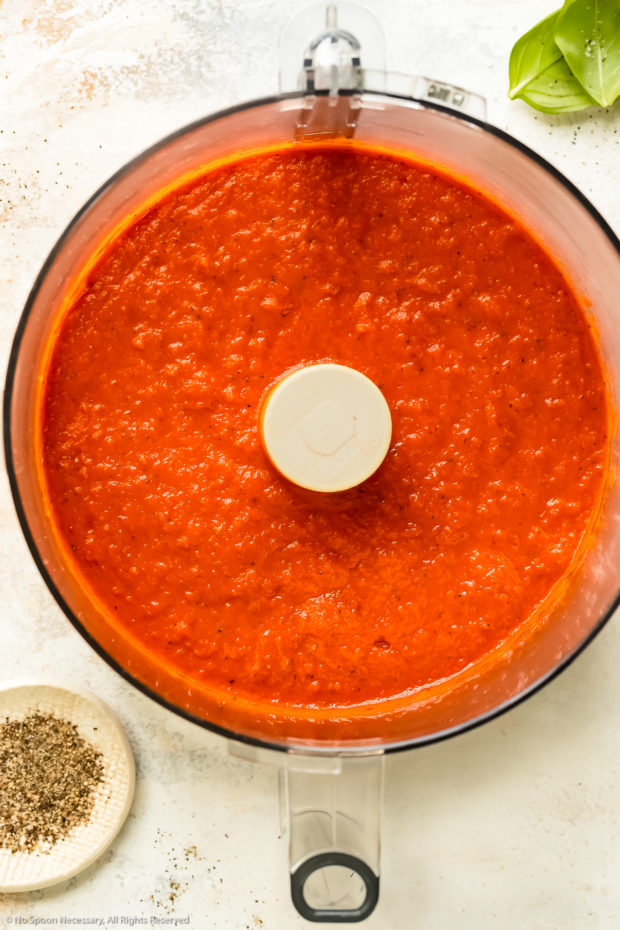 Overhead photo of pureed roasted red pepper pasta sauce in a large food processor bowl.
