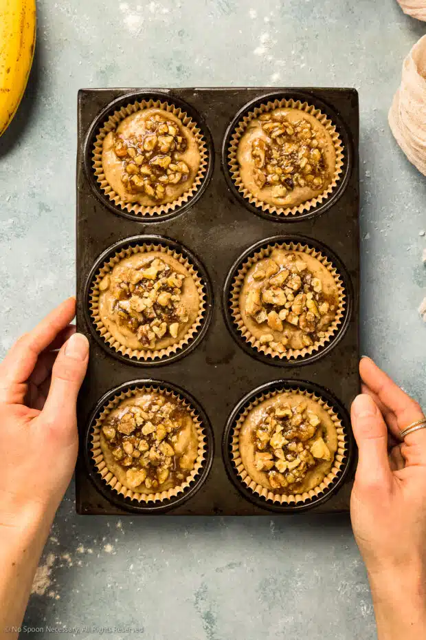 Overhead photo of raw walnut banana muffins in paper liner muffin tins. 