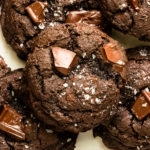 Overhead photo of a chewy triple chocolate cookie stacked on top of more cookies.