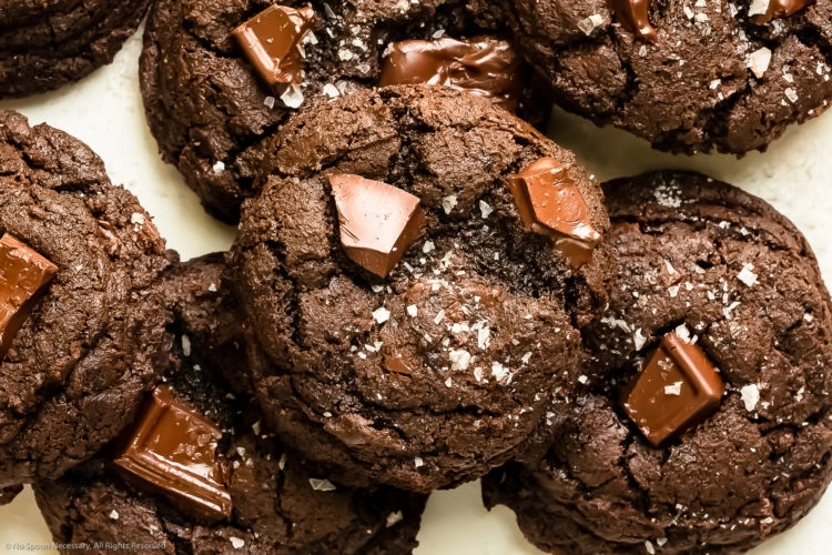 Overhead photo of a chewy triple chocolate cookie stacked on top of more cookies.