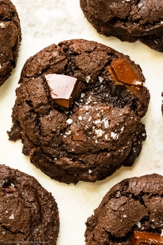 Overhead photo of a triple chocolate cookie sprinkled with flaky salt.