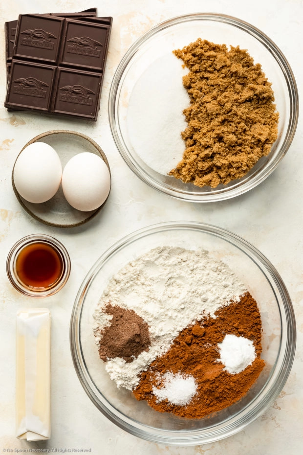 Overhead photo of all the ingredients needed to make chewy chocolate cookies neatly organized in individual glass bowls.