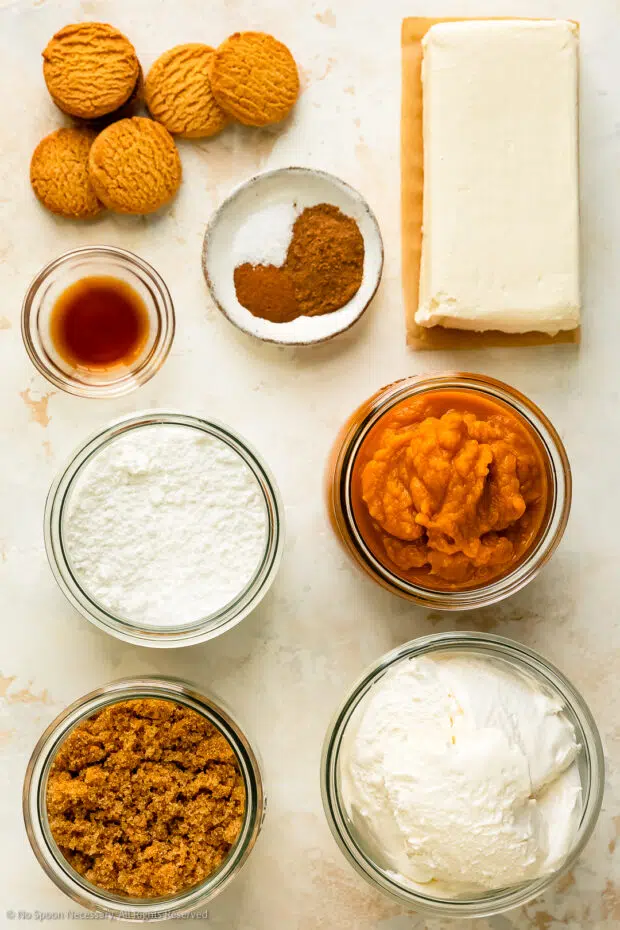 Overhead photo of all the ingredients to make pumpkin cheesecake mousse neatly organized into individual ingredients on a white surface.