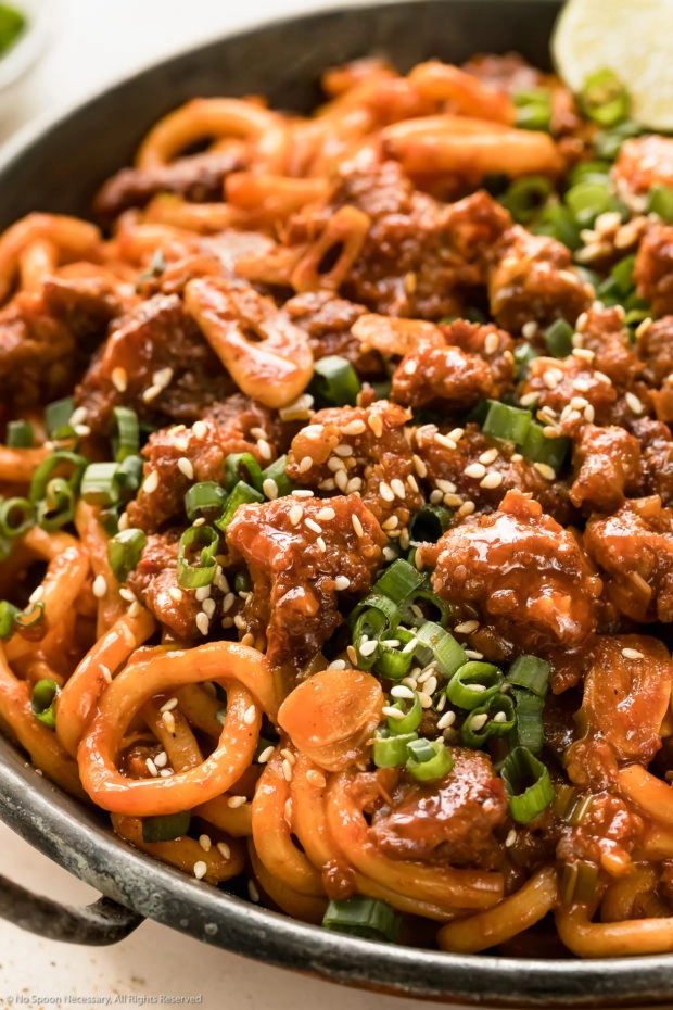 Angled photo of Japanese stir fried udon noodles with pork in a small wok.