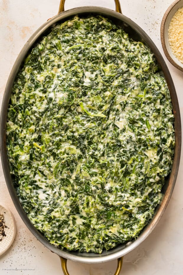 Overhead photo of a casserole with spinach and cheese in a vintage casserole pan.