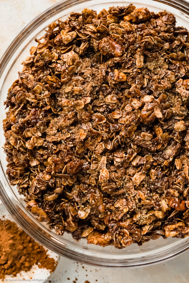Overhead photo of dark chocolate granola mixture (before baking) in a glass mixing bowl.