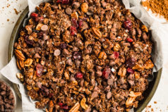 Overhead, landscape photo of dark chocolate granola in a parchment paper lined pan.