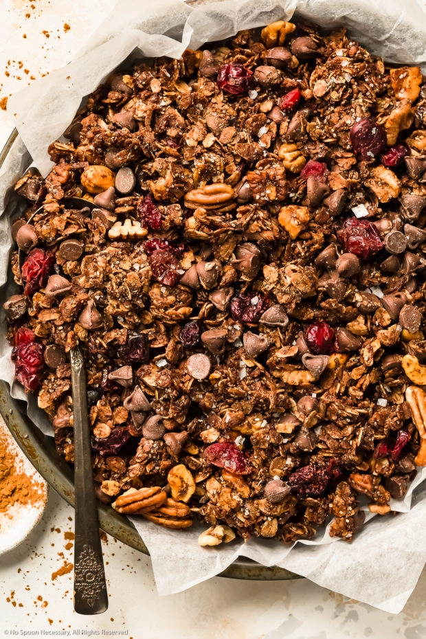 Overhead photo of homemade chocolate granola trail mix in a parchment paper lined pan.