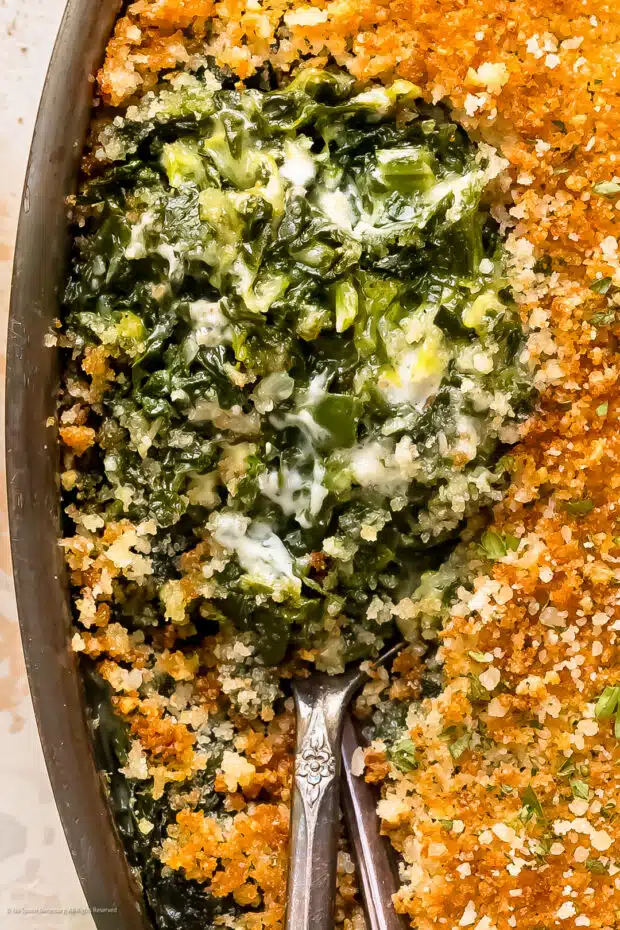 Close-up, overhead photo revealing the creamy interior of creamed spinach casserole.