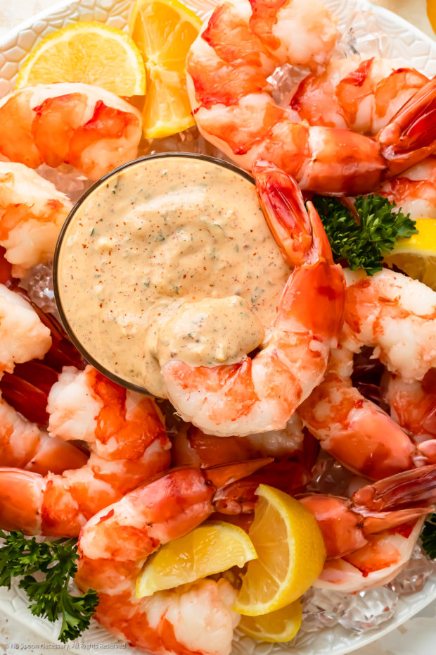 Overhead photo of a bowl of remoulade sauce in the middle of a cocktail shrimp platter.