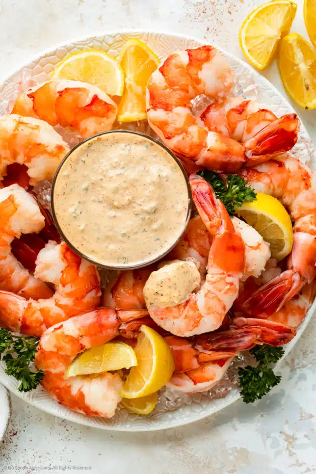 Overhead photo of a cocktail shrimp platter with a bowl of easy remoulade sauce in the middle of the platter.