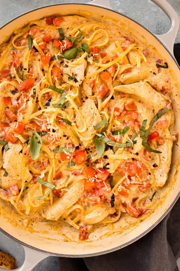 Overhead photo of tomato chicken and pasta in a large skillet.