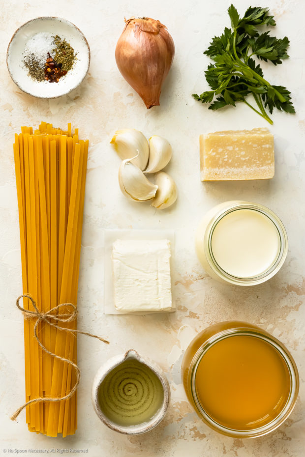 Overhead photo of all the ingredients in cream cheese pasta recipe neatly arranged on a white counter.